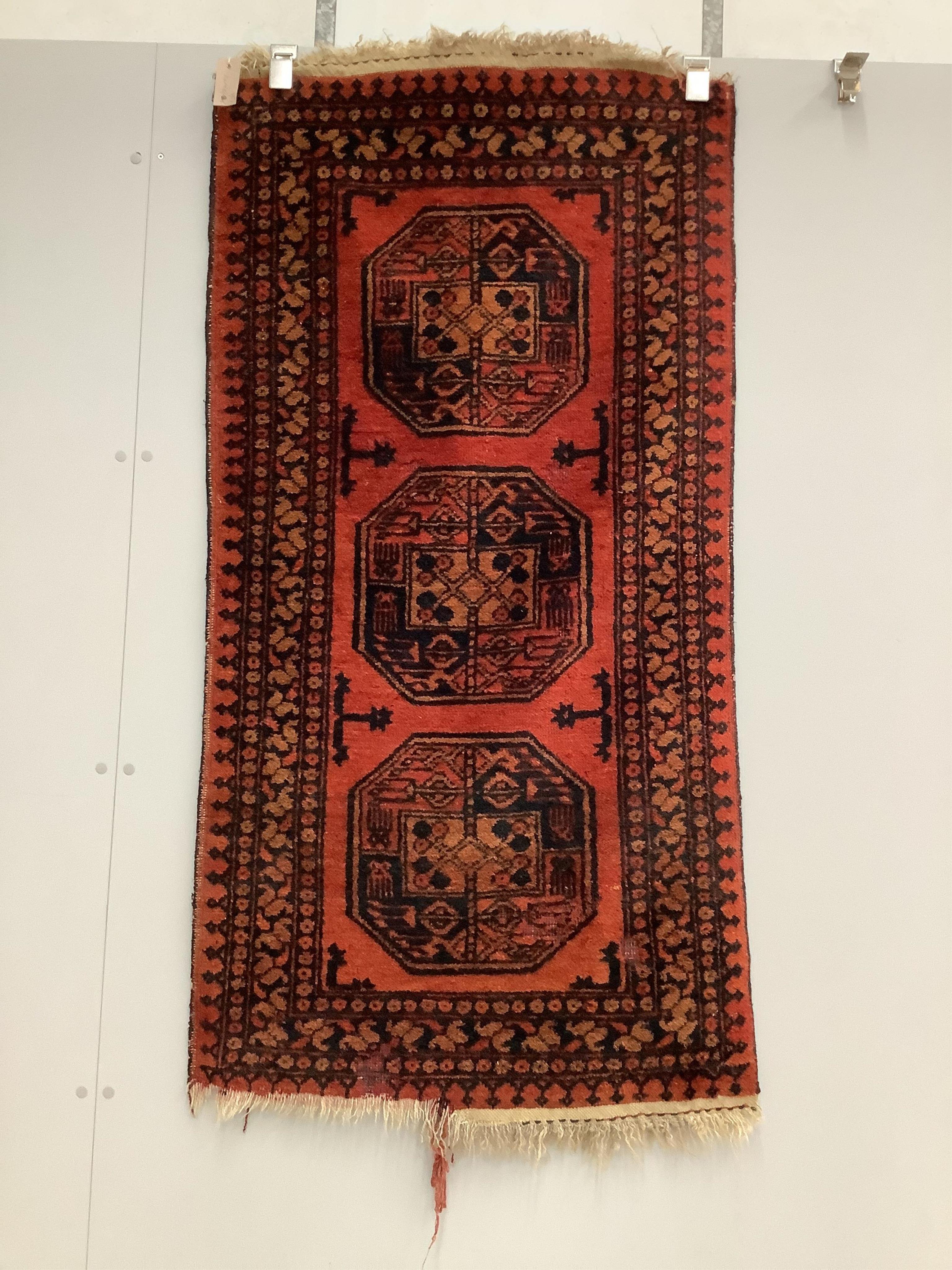 A pair of Afghan red ground rugs, each 144 x 75cm. Condition - fair
